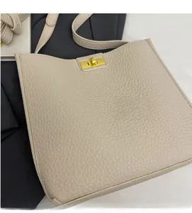 Dettaglio borsa a tracolla beige in pelle grana litchi con chiusura a scatto dorata