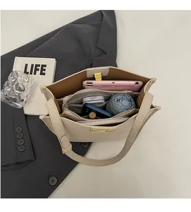 Vista dall'alto dell'interno della borsa capiente con scomparti multipli e dettagli dorati