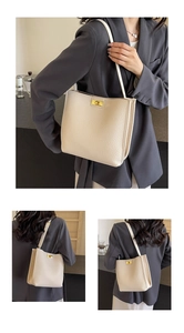 Dettagli di una borsa a secchiello beige in pelle martellata con fibbia in metallo oro