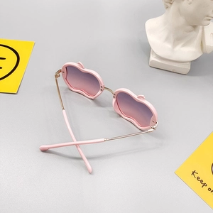Pink apple-shaped kids sunglasses with gradient purple lenses and gold metal temples