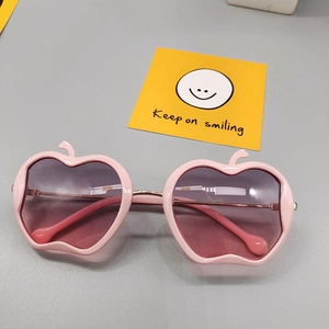 Macro detail of kids apple-shaped pink sunglasses with gradient lenses and round tips