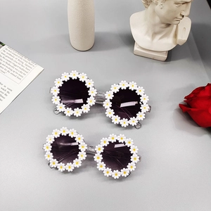 Daisy flower-shaped sunglasses for kids with white frames and dark circular lenses