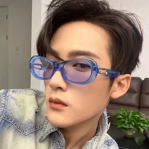 Close-up of trendy oval sunglasses with transparent blue frames and purple tinted lenses