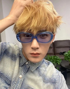 Close-up of stylish oval cat-eye sunglasses with translucent blue frames on a model