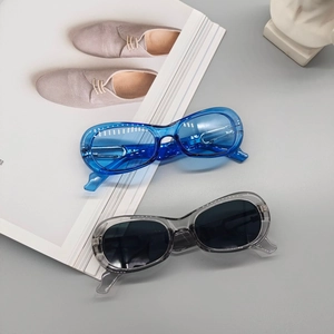 Fashionable oval sunglasses set with transparent blue and grey frames on a minimalist backdrop