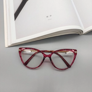Close-up of deep red marble cat-eye glasses frame with premium gold metal hinges