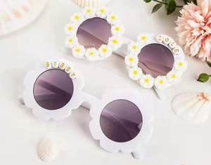 Detailed view of flower shaped girls sunglasses with decorative SISSY and ZOLE beads