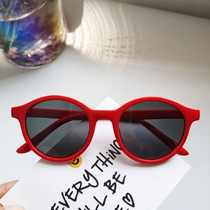 Close-up of bright red round frame kids sunglasses with dark polarized lenses