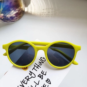 Detail of yellow oval kids polarized sunglasses with matte frame and dark lenses
