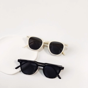 Classic round frame children's sunglasses in beige and black with metal rivet details