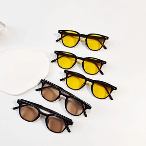Detail of vintage round children's sunglasses with black frames and colorful lenses
