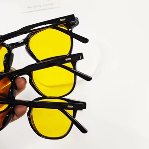 Detail of three retro round kids' sunglasses with black frames and yellow lenses