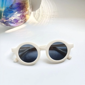 Detail of round cream baby sunglasses with UV protection and smooth thick frames