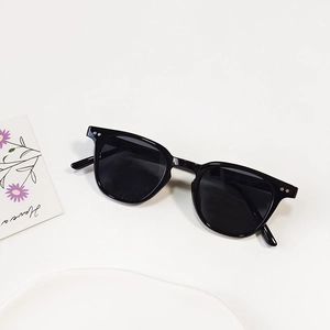 Detail view of round frame sunglasses with silver dots decoration and black lenses