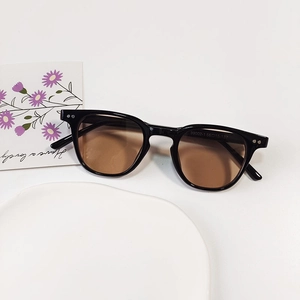 Detail shot of vintage round kids sunglasses with black frames and amber lenses