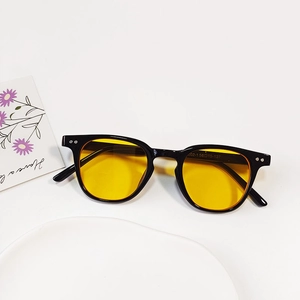 Close-up of black retro child sunglasses with yellow lenses and detailed size specs