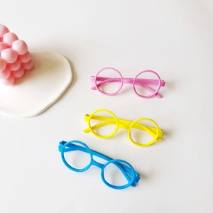 Three pairs of colorful round kids glasses frames in pink, yellow, and blue plastic