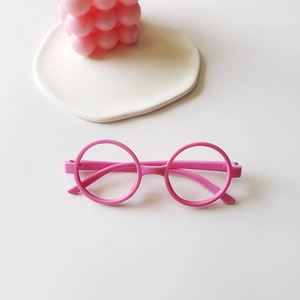 Pink round frame glasses for kids with glossy plastic finish shown on a white tabletop