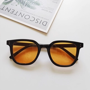 Flat lay of rectangular vintage sunglasses with black frames and yellow lenses