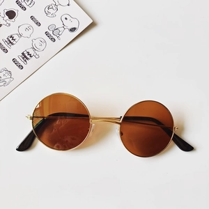 Detail view of round retro kids sunglasses with gold metal frame and brown lenses