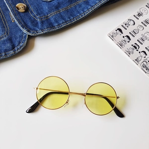 Detail of round gold metal sunglasses with yellow lenses and retro vintage design
