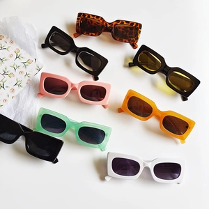 Flat lay of vintage rectangular sunglasses in various colors on white background