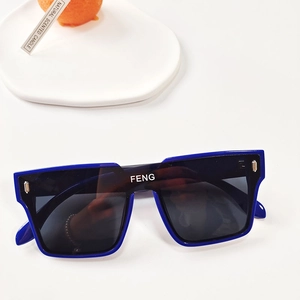 Détail de lunettes de soleil carrées bleues pour enfants avec rivets dorés et verres foncés