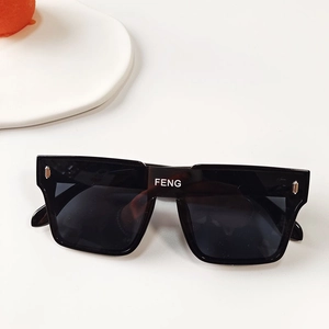Gros plan sur les lunettes de soleil carrées noires avec lettrage FENG blanc sur le pont
