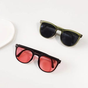 Detail view of foldable kids sunglasses with olive and black frames and tinted lenses