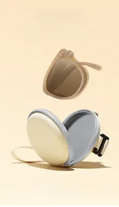 Macro detail of cream round EVA folding sunglasses case with soft grey lining and hook