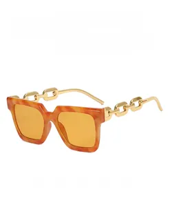 Detail of square sunglasses with tortoise frame and gold metal chain temples