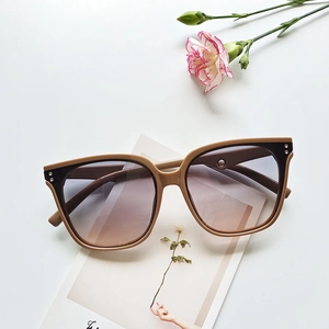 Detail of square gradient tea lenses and stylish bicolor frames with metal studs