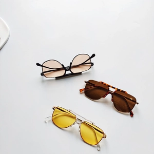 Three pairs of vintage kids sunglasses in black, tortoiseshell and gold frames on white