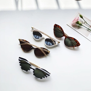 Détail de lunettes de soleil œil de chat avec quatre motifs et chaîne dorée décorative