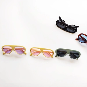 Flat lay of retro oval kids sunglasses in assorted colors on a white background