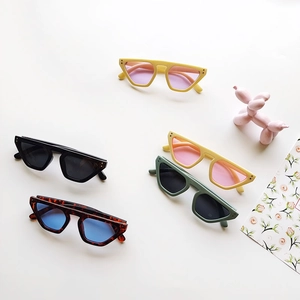 Geometric vintage kids sunglasses collection in various macaron colors on white backdrop