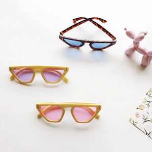 Three pairs of retro geometric kids sunglasses with stylish macaron frames on white surface