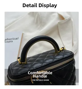 Detail of quilted leather handle and vintage gold metal hardware on black box bag