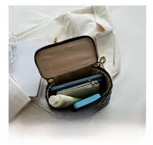 Internal view of black quilted box bag showing spacious capacity for phone and cosmetics
