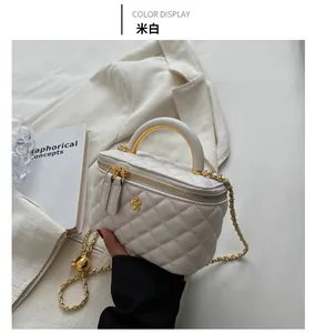 Close-up of quilted beige handbag with gold camellia clasp and sleek metal top handle
