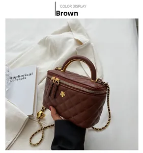 Close-up of brown quilted leather handbag with floral metal detail and chain strap