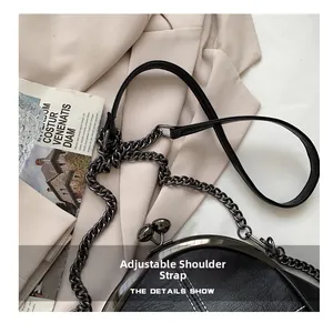 Detail of black shell bag with white contrast stitching and adjustable chain strap