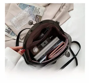 Interior view of spacious shell bag showing perfume, wallet and zipper pocket detail
