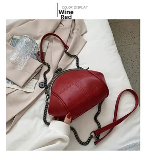 Close-up of wine red shell-shaped handbag featuring classic quilted texture and chain strap