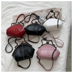 Flat lay of four vintage shell bags in red, black, white, and pink with chain straps