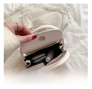Interior view of white leather crossbody bag showing capacity for makeup and cosmetics