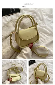 Detail of cream yellow leather handbag with gold hardware and embossed fashion logo