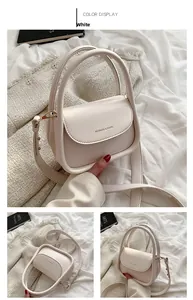 Detail view of cream crossbody bag featuring fashion embossing and gold hardware