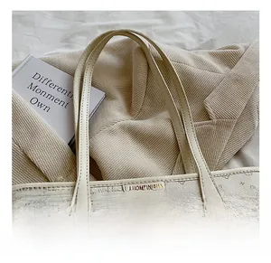 Detail of monogram tote bag featuring animal patterns and brand logo on textured leather