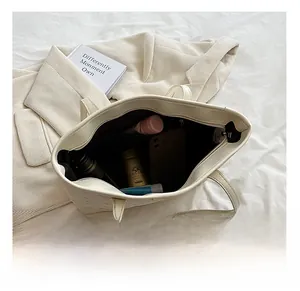 Internal view of a spacious white tote bag showing daily items and inner pockets